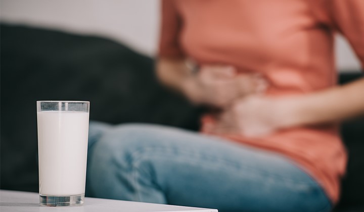 Frau mit Laktoseintoleranz Blähungen durch Unverträglichkeiten