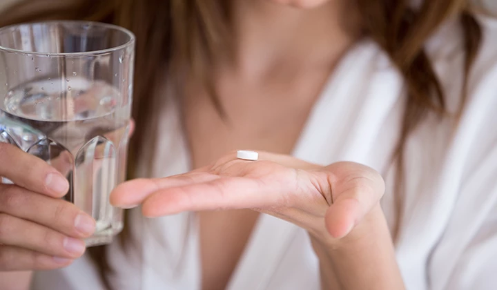 Frau nimmt Antibiotikum Darmflora-Aufbau nach Antibiotika