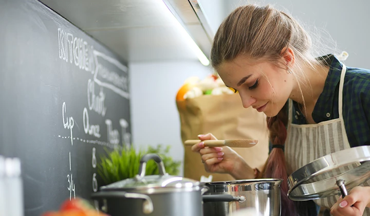 Frau schmeckt Suppe ab Schonkost richtig zubereiten