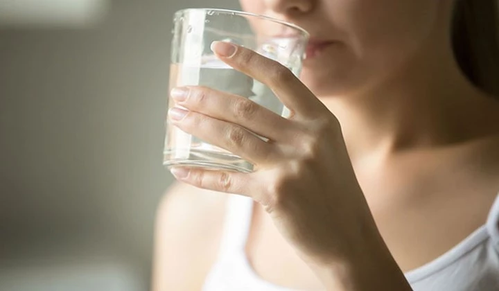 Frau mit Wasserglas Viel trinken als Ernährungstipp
